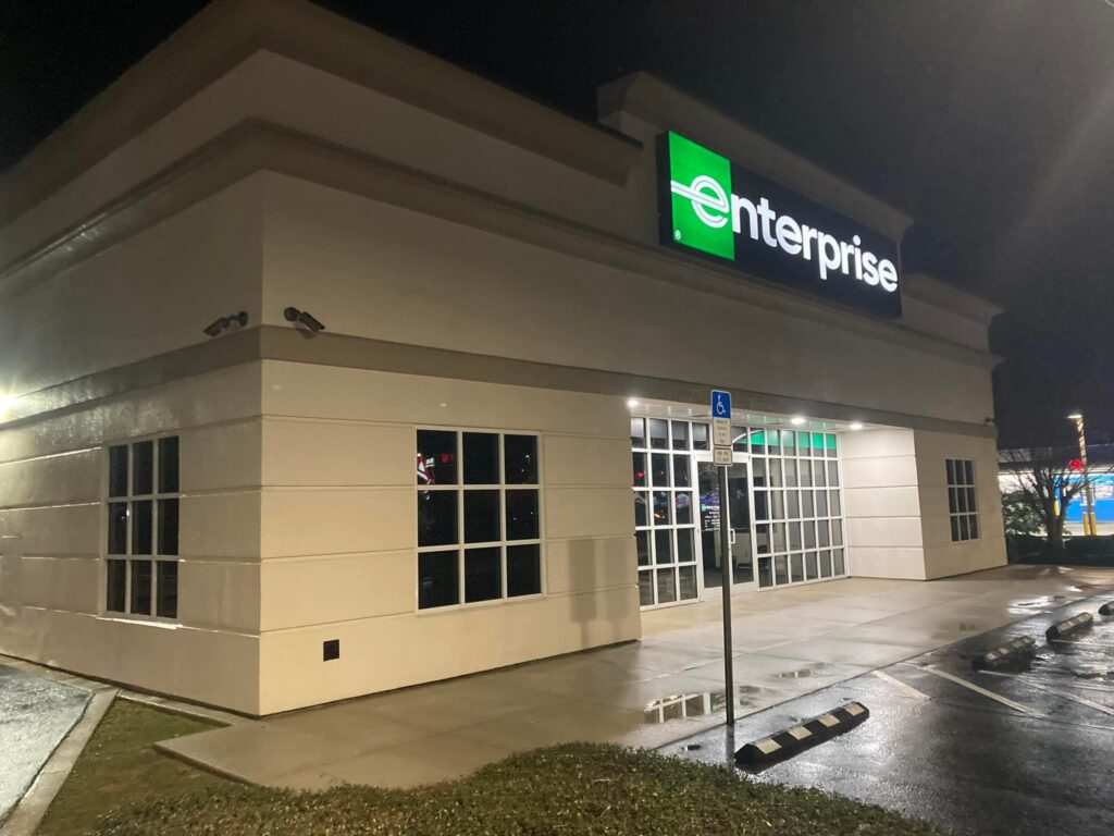 Well-lit Enterprise Rent-A-Car commercial property exterior at night.